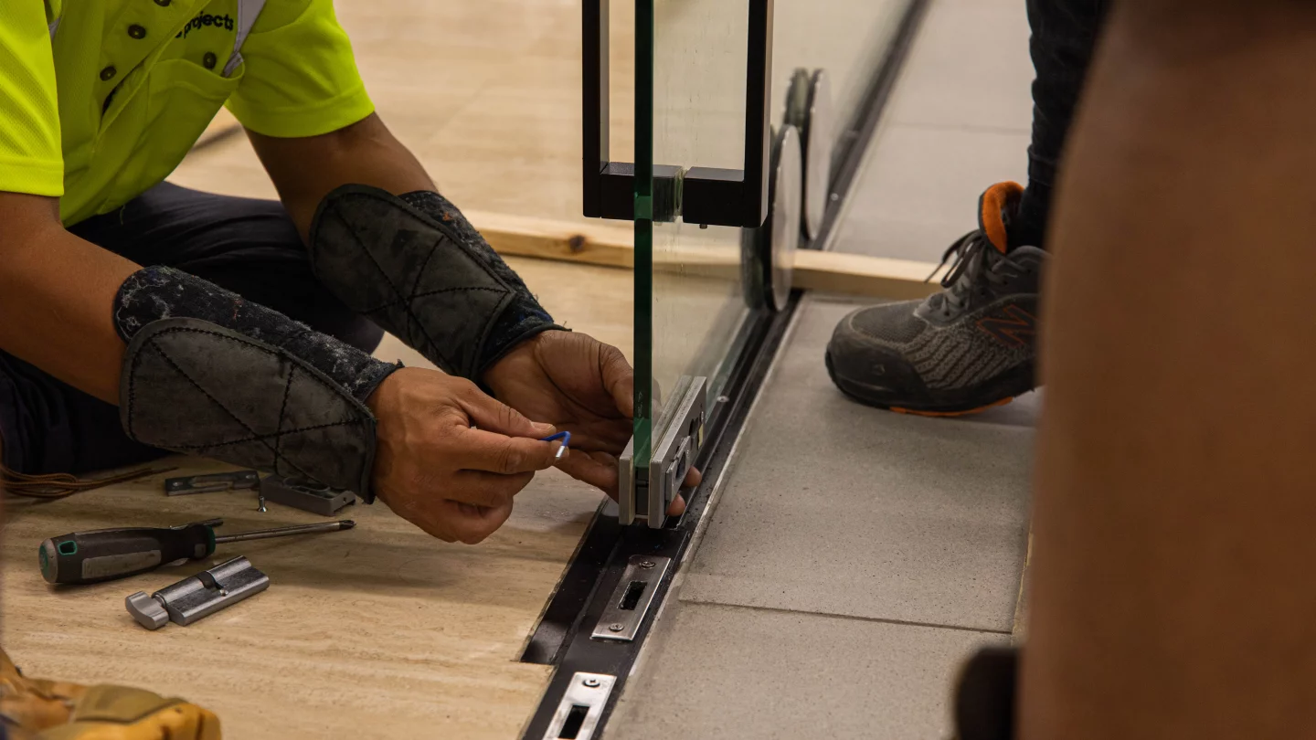 Closeup of glass door hardware being installed